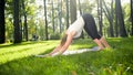 Photo of middle aged woman in sportrs clothes practicing yoga outdoors at park. Middle aged woman stretching and Royalty Free Stock Photo