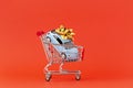 Image of miniature shopping trolleys on red background. Miniature car in shopping cart. Concept shopping and sale. Royalty Free Stock Photo