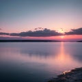 Misty seascape - calm water surface of the lake reflects lilac sky with pink and blue clouds after sunset. White