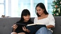 Mother and daughter using digital tablet doing school homework at home. Online education concept. Royalty Free Stock Photo