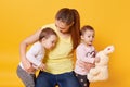 Image of mother with kids, playing with mommy while posing in photo studio, girl holds plushy rabbit, toddlers dressed in casual Royalty Free Stock Photo