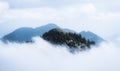 Image of mountain peak with cross surrounded by clouds Royalty Free Stock Photo
