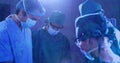 Image of moving lights over group of surgeons in operating theatre Royalty Free Stock Photo
