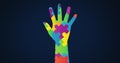 Image of multi coloured puzzle elements forming hand, symbol of Autism Awareness Month symbol Royalty Free Stock Photo