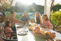 Image of multi generation caucasian family eating outdoor dinner Royalty Free Stock Photo