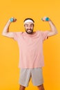 Image of muscular athletic young man having fun and lifting dumbbells Royalty Free Stock Photo