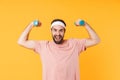 Image of muscular athletic young man having fun and lifting dumbbells Royalty Free Stock Photo