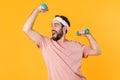 Image of muscular athletic young man having fun and lifting dumbbells Royalty Free Stock Photo