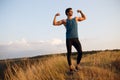 Image of a muscular, strong, fit, abs, sportive young man shows his muscles, over landscape background. Royalty Free Stock Photo