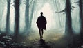 Mysterious dark forest with a man in a long cloak. Royalty Free Stock Photo