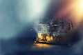 Image of mysterious magical treasure chest with light over wooden old table and dark background