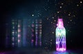 image of mystic bottle with glitter lights next to antique books on wooden table