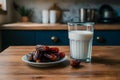 Image Neat arrangement of dates next to a glass of milk on the kitchen table