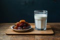 Image Neat arrangement of dates next to a glass of milk on the kitchen table