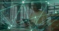 Image of network of connections over biracial man using tablet Royalty Free Stock Photo