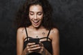 Image of nice delighted woman smiling and using cellphone