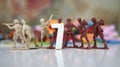 Image of number 7 with seven toy soldiers at background