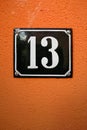 the number thirteen on an orange wall Royalty Free Stock Photo