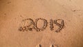 Photo of numbers 2019 written on wet sand on the sea beach. Concept of winter holidays, New Year and tourism Royalty Free Stock Photo