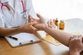 Image of a nurse checking a patient`s pulse. A female doctor shakes hands giving her male patient reassurance and consultation.