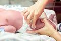 Image of nurse hands using cotton wool swab with alcohol to clean the baby`s leg skin before vaccination Royalty Free Stock Photo