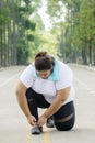 Obese woman tying her shoelaces on the road Royalty Free Stock Photo