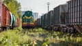 Image of old diesel train and long rows of cargo trains and wagons on trasportation hub Royalty Free Stock Photo
