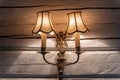 Old vintage bronze double lamp on the white wooden wall Royalty Free Stock Photo