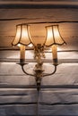 Old vintage bronze double lamp on the white wooden wall