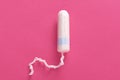 Image of one unused clean tampon being isolated over pink background, product for menstruation, disposable feminine hygiene thing Royalty Free Stock Photo