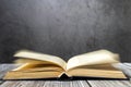 Image of an open antique book on a wooden table against a dark background. Royalty Free Stock Photo