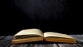 Image of an open antique book on a wooden table against a dark background. Royalty Free Stock Photo