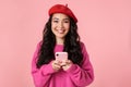 Image of optimistic beautiful asian girl smiling and holding smartphone