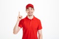 Image of optimistic delivery man in red t-shirt and cap smiling