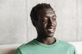 Image of optimistic joyful african american man sitting on sofa at home