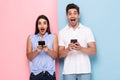 Image of optimistic man and woman in casual wear holding mobile