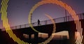 Image of orange line spiral rotating over man running on bridge at sunset in city