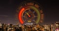 Image of orange speedometer over night cityscape