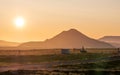 Orange sunset over the mountain with helicopter parked in front of it in Iceland