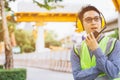 Image outside the industrial construction engineers in yellow protective ear muff discuss new project while using walkie talkie Royalty Free Stock Photo