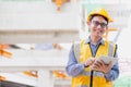 Image outside the industrial construction engineers in yellow protective helmet discuss new project while using laptop