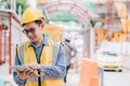 Image outside the industrial construction engineers in yellow protective helmet discuss new project while using laptop Royalty Free Stock Photo