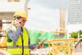 Image outside the industrial construction engineers in yellow protective helmet discuss new project while walkie talkie Royalty Free Stock Photo