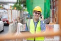 Image outside the industrial construction engineers in yellow protective helmet discuss new project while walkie talkie and happy Royalty Free Stock Photo