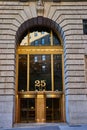 Outside New York City building 26 with golden frame and stone arch over huge entrance