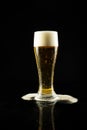 Image of overflowing pint glass of foamy beer, with copy space on black background