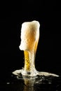 Image of overflowing pint glass of foamy beer, with copy space on black background
