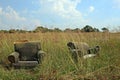 ABANDONED DISTORTED UPHOLSTERED CHAIRS IN A FIELD