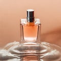 Image in peach fuzz tones of perfume bottle in water on peach color background. Perfume advertisement Royalty Free Stock Photo