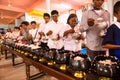 Image of people in buddhist temple paying respect to monks. Religious celebration. People serving rice to monks. Royalty Free Stock Photo